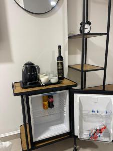 a small refrigerator with its door open and a bottle of wine at StonSoldo Rooms in Ston