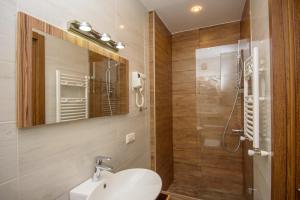 a bathroom with a sink and a mirror and a shower at Hotel Beli in Tbilisi City