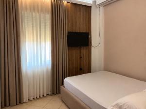 a bedroom with a bed and a flat screen tv at Eid Mar in Vlorë