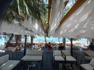 a restaurant with white chairs and umbrellas on the beach at Apartment Sunset in Trogir