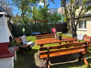 a picnic table with benches and a swing at Domek Bałtycki Lux in Rewa