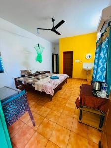 a bedroom with a bed and yellow walls at iha ayurveda resort in Varkala