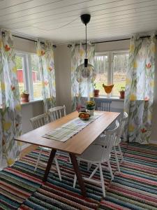 a dining room with a wooden table and chairs at Rosebo in Tranås