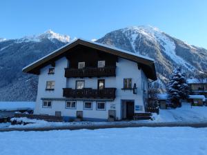 a large white building with mountains in the background at Gästehaus Posch in Krimml