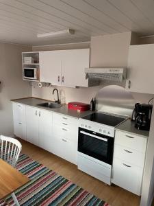 a kitchen with white cabinets and a stove top oven at Rosebo in Tranås +14 photos