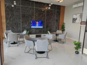 a room with chairs and tables and a tv on a wall at شقق أجنحة نزيل للشقق المخدومة in Tabuk
