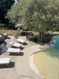 a group of lounge chairs next to a swimming pool at La Bernarde in Tourrettes