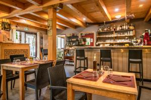 a restaurant with wooden tables and chairs and a bar at Hôtel Restaurant L'Arbre à Pain in Altier