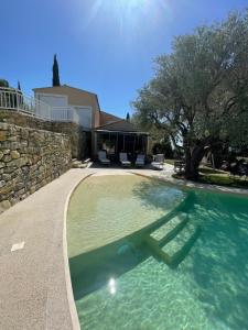 a swimming pool in a yard with a house at La Bernarde in Tourrettes