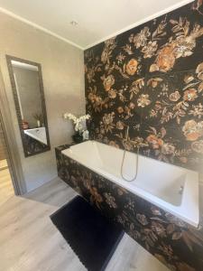 a bathroom with a bath tub with a floral wallpaper at La Bernarde in Tourrettes +25 photos