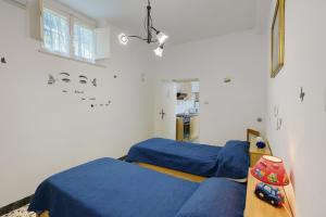 two beds in a room with blue sheets at Bella veduta Sun in Agerola