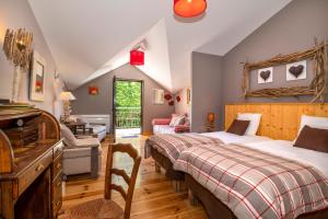 a bedroom with two beds and a living room at Hôtel Restaurant L'Arbre à Pain in Altier