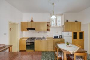 a kitchen with wooden cabinets and a table in it at Bella veduta Sun in Agerola