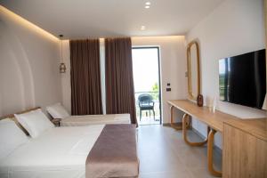 a hotel room with a bed and a television at Uzeiri Guest Hotel in Borsh