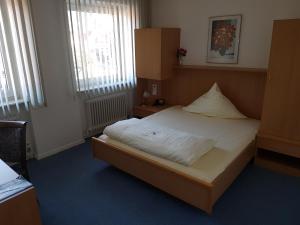 Hotel Stadt Baunatal في باوناتال: غرفة نوم بها سرير مع صندوق عليه