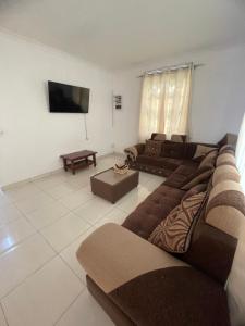 a living room with two brown couches and a flat screen tv at Casa Lotus in Pereybere