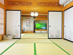an empty room with a television in a building at 富士山を眺められる宿 ゲストハウス花水木 in Nishikatsuracho