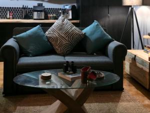 a couch with pillows and a table in a living room at Renosterveld Eco Pods in Swellendam