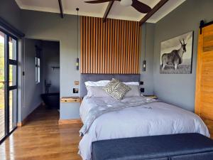 a bedroom with a bed with a deer on the wall at Renosterveld Eco Pods in Swellendam