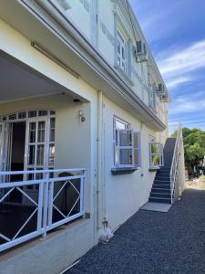 a white building with a balcony and stairs at Casa Lotus in Pereybere