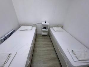 two beds in a room with a table and a chair at Хостел in Astana