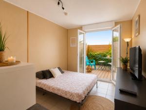 a bedroom with a bed and a tv and a balcony at Appartement entier en centre-ville avec terrasse in La Rochelle