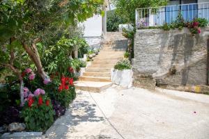 a set of stairs leading to a house with flowers at Uzeiri Guest Hotel in Borsh