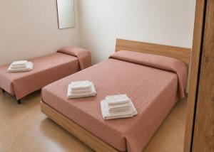 a room with two beds with towels on them at Dimora Azzurra in Pachino
