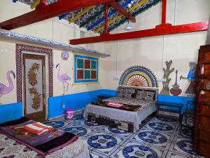 a room with a bed and a mural on the wall at White Land Village Stay in Dhordo