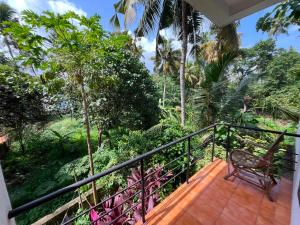 a balcony with a chair and trees at iha ayurveda resort in Varkala