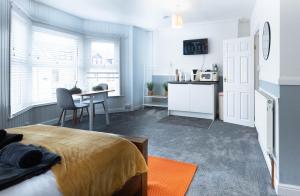 a bedroom with a bed and a table and a kitchen at The Bay by Guestz in Morecambe
