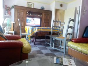 a living room with a tv and a table and chairs at Maison complète in Montluçon