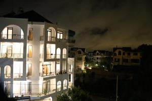 a large white building at night with buildings at Enjoy Villa Da Lat in Khu Chi Lăng