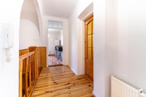 a hallway with a wooden floor and a door at Dwupoziomowy apartament, 4 pokoje in Dęblin