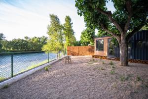 a cabin by the water with a tree at Cabañas en Graus in Graus