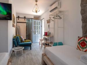 a bedroom with a bed and a couch and a chair at Naiada Home with Sea View in Mykonos