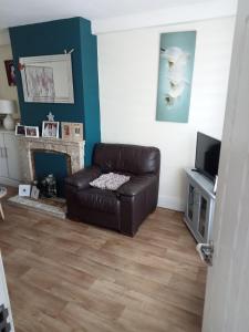 a living room with a leather couch and a tv at Cozy stay in Dublin