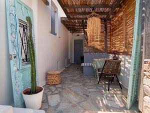 a patio with a table and a cactus in a room at Naiada Home with Sea View in Mykonos