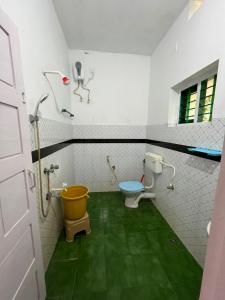 a bathroom with a toilet and a yellow bucket at iha ayurveda resort in Varkala