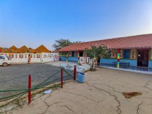 a building with a basketball court in front of it at White Land Village Stay in Dhordo