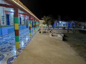a row of colorful poles on a building at night at White Land Village Stay in Dhordo +17 photos