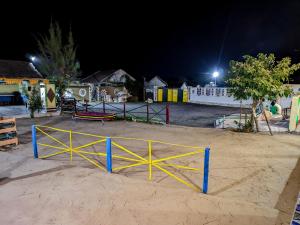 a gate in the sand in a playground at night at White Land Village Stay in Dhordo