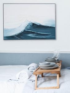 a painting on a wall above a bed with a table at The Bay by Guestz in Morecambe +109 photos