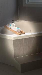 a bath tub with a bottle of soap on it at Venus Resort in The Entrance +67 photos