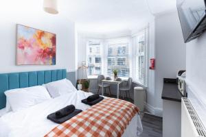 a bedroom with a bed with two black towels on it at The Bay by Guestz in Morecambe
