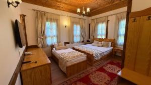 a bedroom with two beds and a tv and windows at Rum Evi By Secret Sense Collection in Safranbolu +24 photos