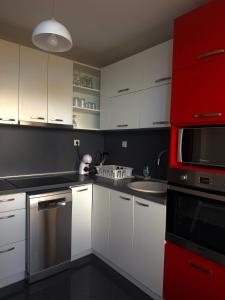 a kitchen with white cabinets and a red appliance at E2 Residence in Balchik