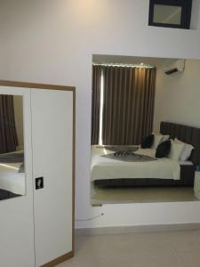 a bedroom with a large bed and a mirror at Room View boutique in Luanda