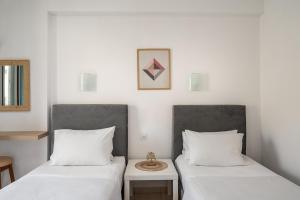 two beds sitting next to each other in a room at Dora Pool Studios by Konnect,150m from the Beach in Agios Georgios