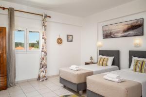 a hotel room with two beds and a window at Dora Pool Studios by Konnect,150m from the Beach in Agios Georgios
